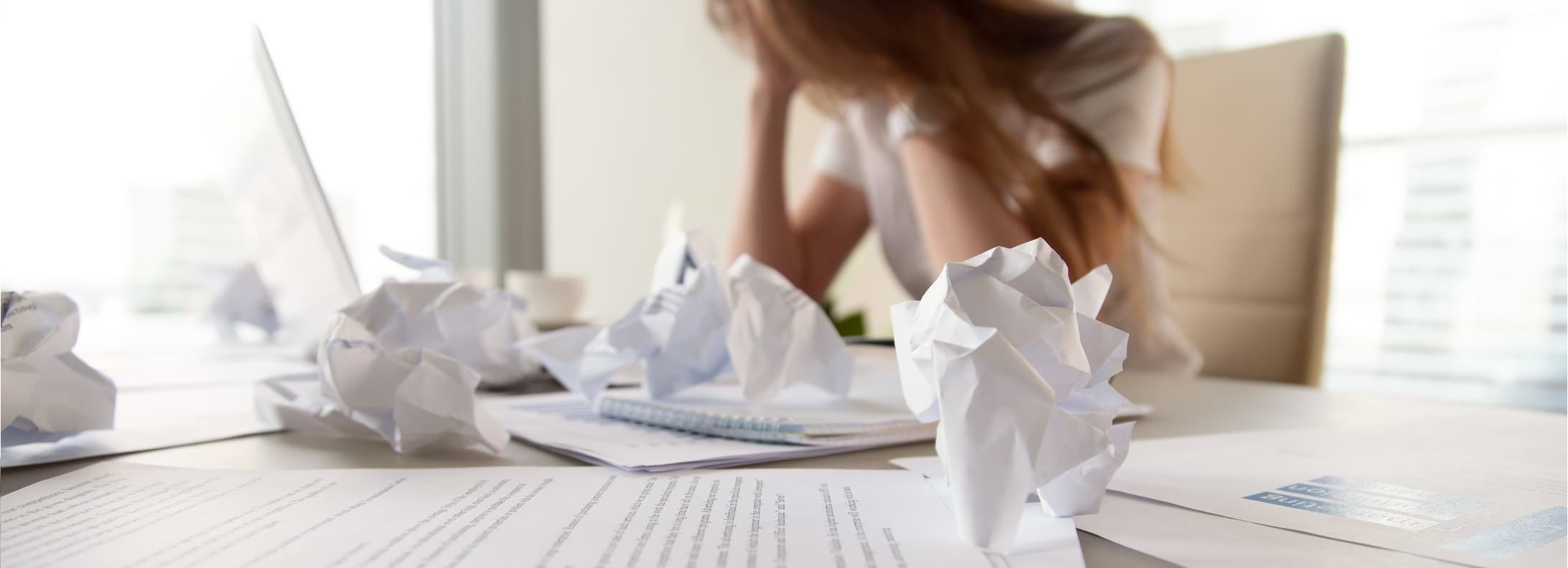 Kvinna med huvudet i händerna vid dator